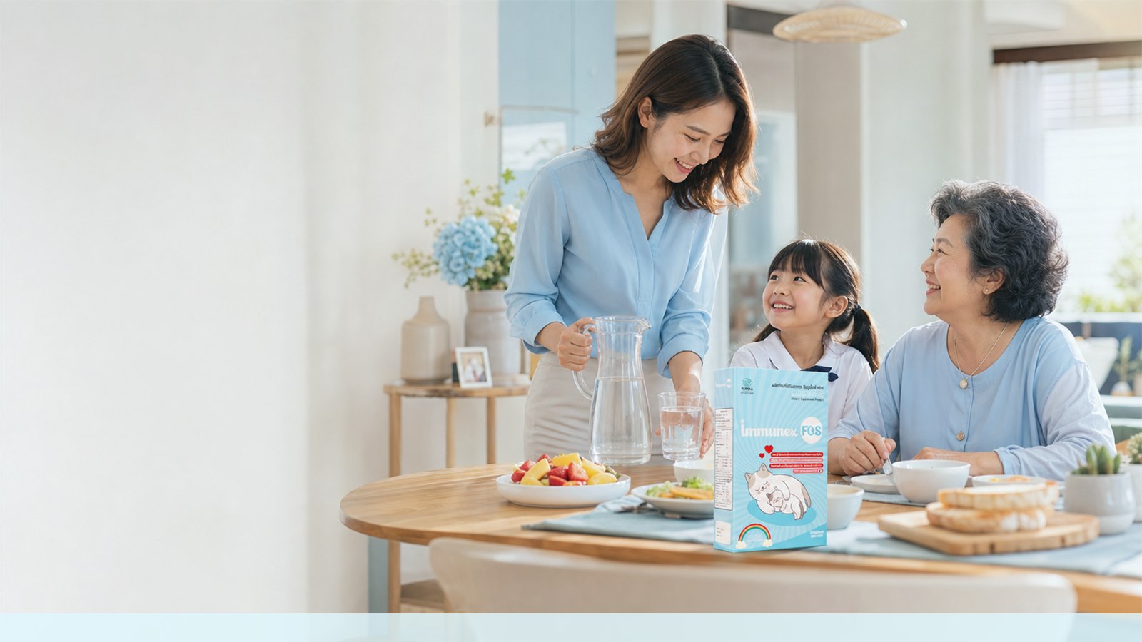 Thai multigenerational family at breakfast with water, fruit, and an IMMUNEX FOS package