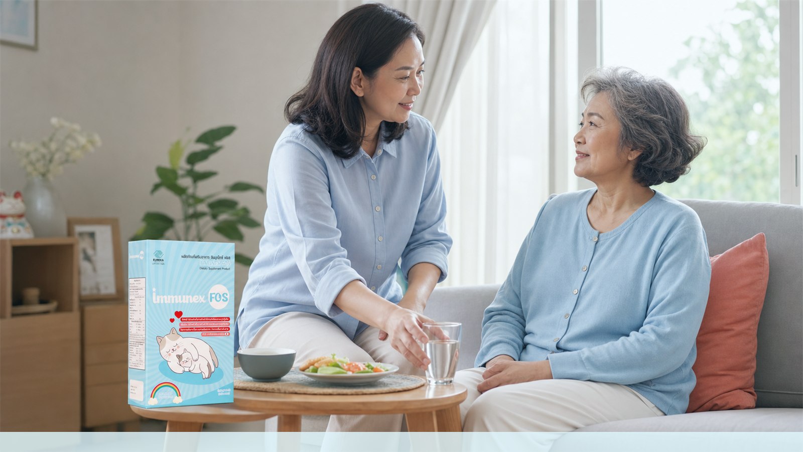 Thai caregiver and older adult together at home with an IMMUNEX FOS package and a glass of water