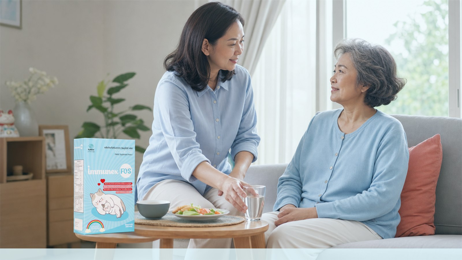 Thai caregiver and older adult together at home with an IMMUNEX FOS package and a glass of water